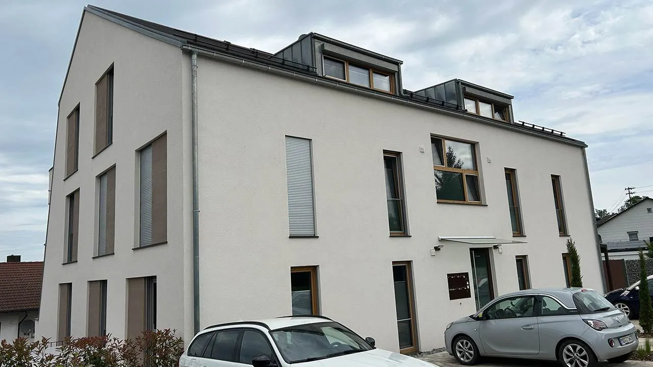 Foto des Eingangs eines modernen Mehrfamilienhauses von außen.